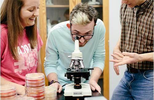 student looking through microscope